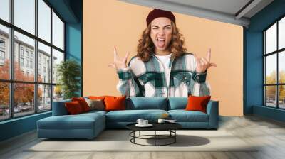 Photo of sassy young woman winking and making horns with fingers Wall mural