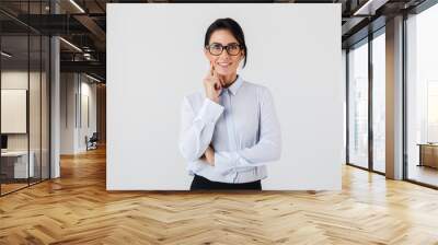 Photo of successful businesswoman wearing eyeglasses standing in the office, isolated over white background Wall mural