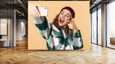 Photo of woman taking selfie on cellphone and pointing finger at camera Wall mural