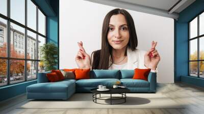 Photo of young businesswoman posing with fingers crossed for good luck Wall mural