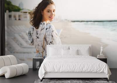 Pleased happy young beautiful woman at the beach running in a beautiful sunny morning. Wall mural