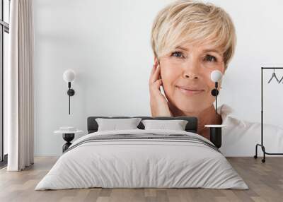 Portrait closeup of beautiful adult woman with short blond hair wearing earpods Wall mural