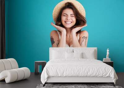 Portrait of a cheerful smiling girl in straw hat Wall mural