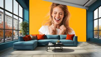 Portrait of a cheerful young blonde girl jumping Wall mural