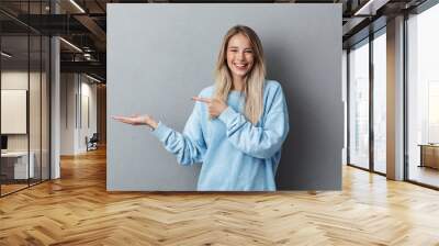 Portrait of a cheerful young girl in blue sweatshirt Wall mural