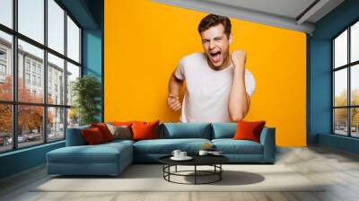 Portrait of a cheerful young man celebrating Wall mural