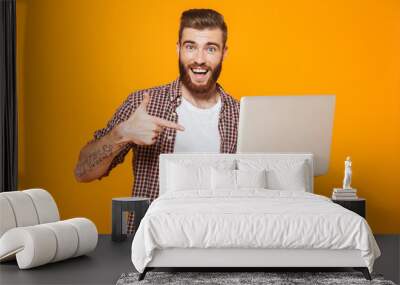 Portrait of a cheerful young man wearing casual clothes Wall mural