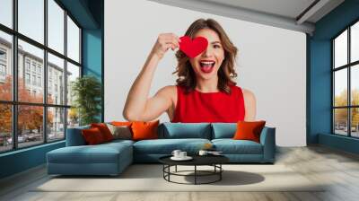 Portrait of a cheerful young woman dressed in red dress Wall mural