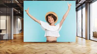 Portrait of a cheerful young woman in summer hat Wall mural