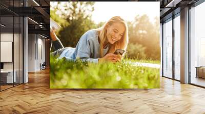 Portrait of a cute young girl laying on a grass at the park Wall mural