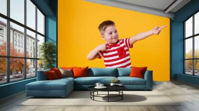 Portrait of a funny little kid pointing fingers away Wall mural