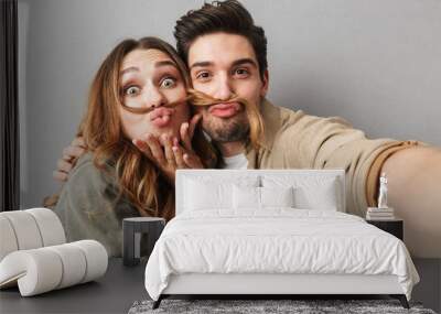 Portrait of a funny young couple hugging taking a selfie Wall mural