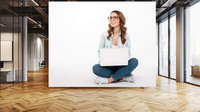 Portrait of a happy casual girl holding laptop computer Wall mural