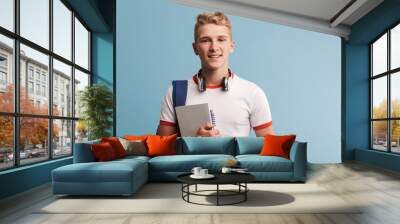 Portrait of a happy casual teenage boy with backpack Wall mural