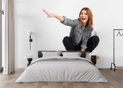 Portrait of a happy cheerful girl riding a skateboard Wall mural