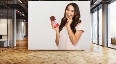 Portrait of a happy young asian woman eating chocolate Wall mural