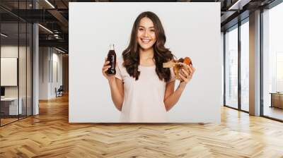 Portrait of a happy young asian woman holding burger Wall mural