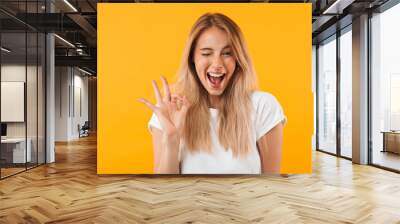 portrait of a happy young blonde girl showing ok gesture Wall mural