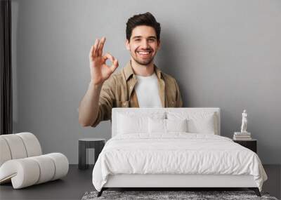 portrait of a happy young casual man showing ok gesture Wall mural