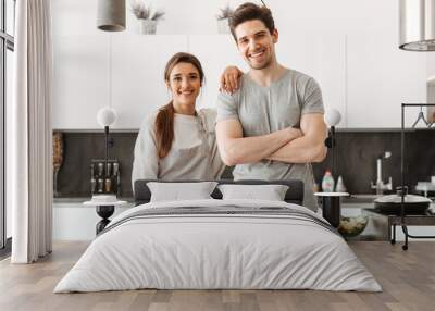 Portrait of a happy young couple at the kitchen Wall mural