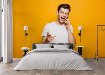 Portrait of a happy young man talking on mobile phone Wall mural