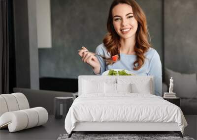 Portrait of a happy young woman eating fresh salad Wall mural