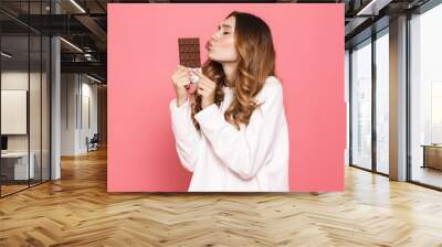 Portrait of a happy young woman kissing chocolate bar Wall mural