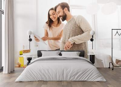 Portrait of a joyful young couple cooking salad Wall mural