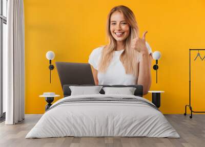 Portrait of a smiling young blonde girl holding laptop Wall mural