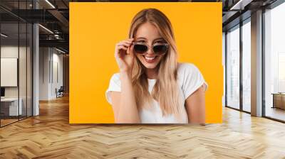 Portrait of a smiling young blonde girl in sunglasses Wall mural