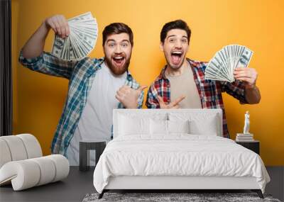 Portrait of a two excited oung men showing money Wall mural