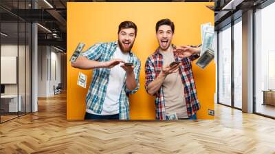 Portrait of a two happy young men scattering money Wall mural