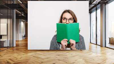 Portrait of a young casual girl holding opened book Wall mural