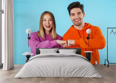 Portrait of a young couple wearing hoodies Wall mural