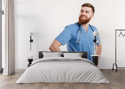 Portrait of a young smiling positive man doctor with stethoscope Wall mural