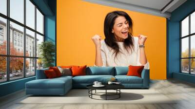 Portrait of an excited young woman celebrating success Wall mural