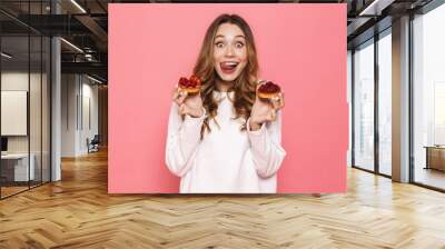 Portrait of an excited young woman holding pastry Wall mural