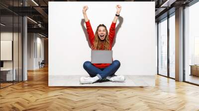 Portrait of an excited young woman wearing hoodie Wall mural