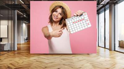 Portrait of an happy girl in summer hat pointing finger Wall mural