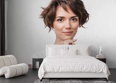 Portrait of cute woman with short brown hair in basic t-shirt looking at camera Wall mural