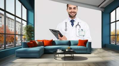 Portrait of european young medical doctor smiling at camera and holding health card Wall mural