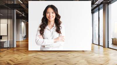 Portrait of gorgeous asian woman with long dark hair looking at camera with beautiful smile and arms crossed, isolated over white background in studio Wall mural