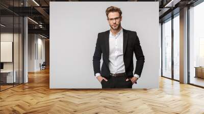 Portrait of handsome businessman posing and looking at camera Wall mural