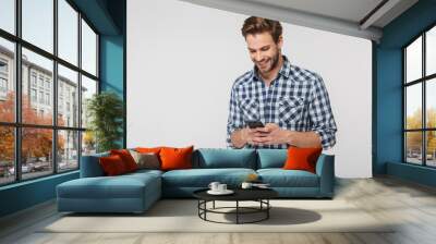 Portrait of happy young man smiling and using cellphone Wall mural