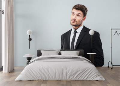 Portrait of pensive young businessman thinking and using tablet Wall mural