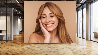 Portrait of shirtless adult woman touching her face and smiling Wall mural