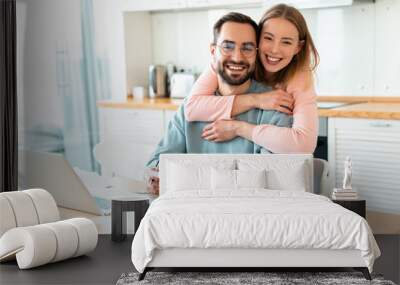 Portrait of smiling couple hugging while working with documents Wall mural