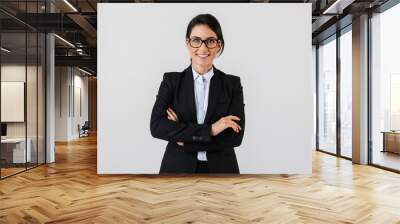 Portrait of successful businesswoman 30s in formal wear and eyeglasses standing in the office, isolated over white background Wall mural