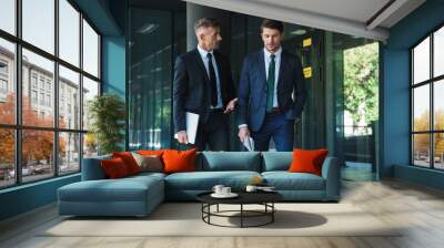 Portrait of two concentrated businessmen partners having conversation outside job center during working meeting Wall mural