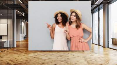 Portrait of two lovely young women dressed in summer clothes Wall mural